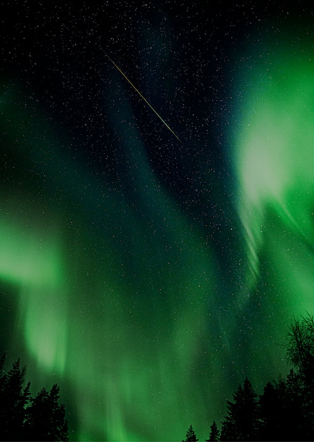 Imagem noturna de uma aurora boreal e um céu estrelado